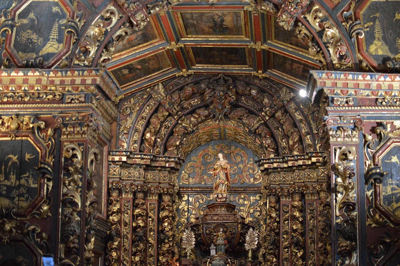 Interior da Igreja do Ó com altar de talha dourada, colunas ornamentadas, teto pintado e painéis laterais com paisagens.