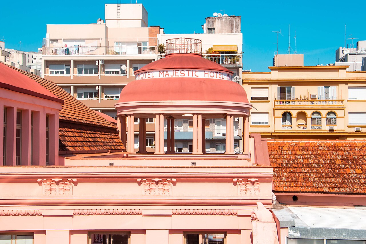 Cúpula rosa com inscrição Hotel Majestic na Casa de Cultura Mario Quintana, entre telhados e prédios vizinhos.