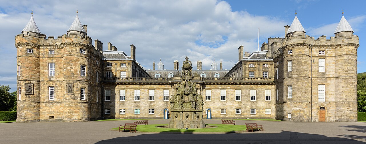 Fachada de pedra de Holyroodhouse com torres cilíndricas, numerosas janelas e monumento ornamentado no pátio.