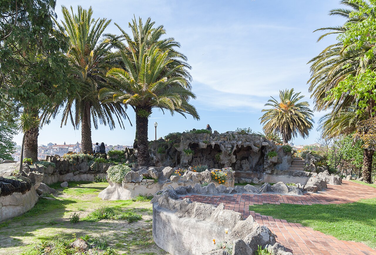 Palmeiras, gramados, canteiros e caminhos entre estruturas de pedra no Jardim do Morro, em Vila Nova de Gaia.