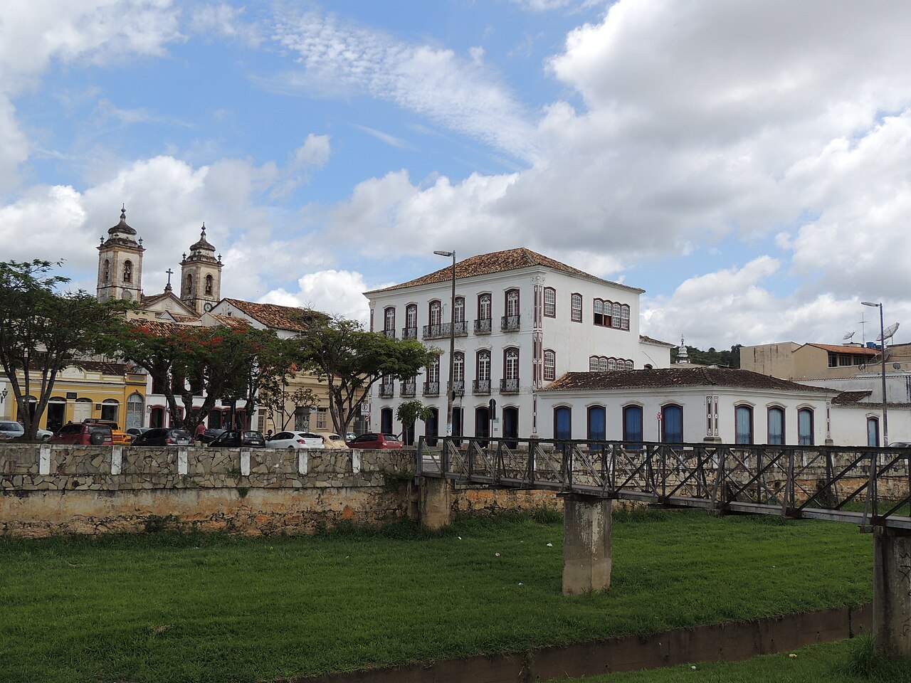 Edifício branco de três pavimentos do Museu Regional, com sacadas, telhado de cerâmica e uma passarela sobre o canal em primeiro plano.